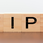Wooden blocks spelling "TIP," representing practical advice for maintaining clean gutters during fall.