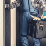 HVAC technician in work attire holding a toolbox, ready to provide heating and cooling maintenance services for homeowners.