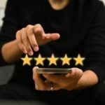 Person using smartphone to rate service with five stars, emphasizing customer satisfaction and positive reviews for HVAC maintenance providers.
